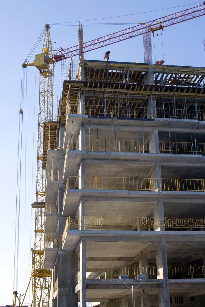 service-02 High-rise building under construction with a tower crane. Captures the modern construction process.